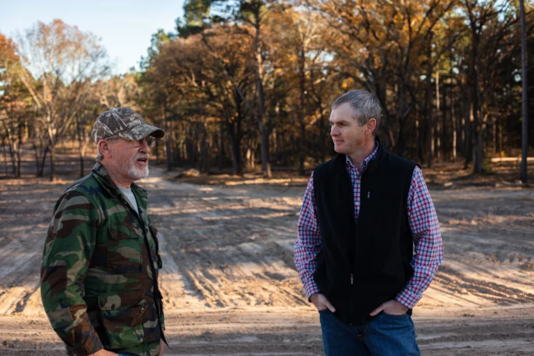 Brandon Bing talking with a farmer/rancher on a dirt backroad.
