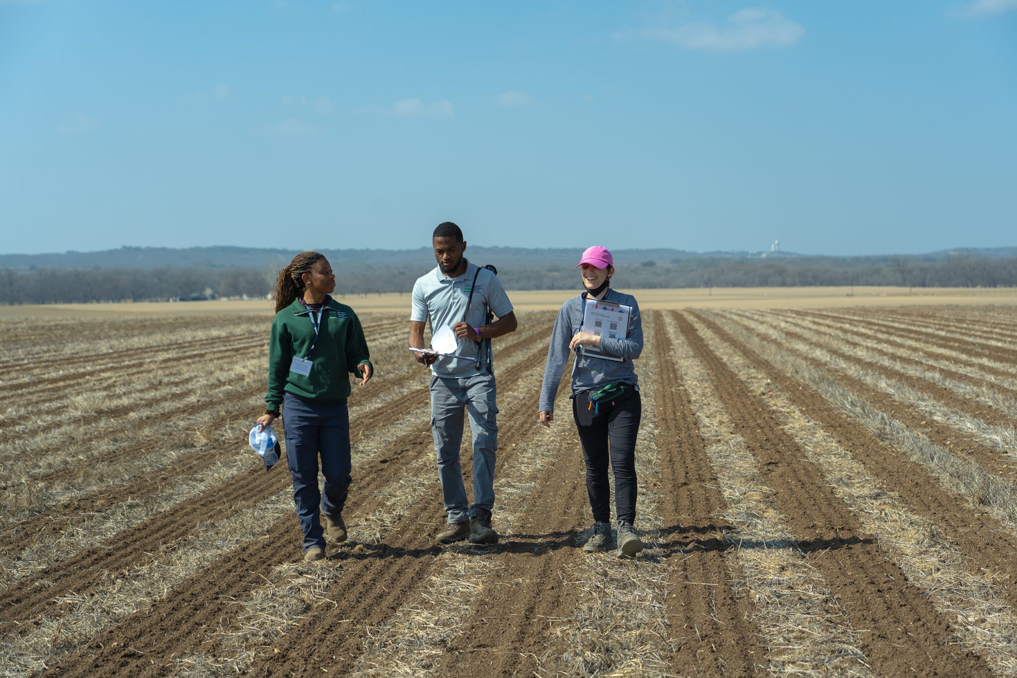 3 people walking in a field